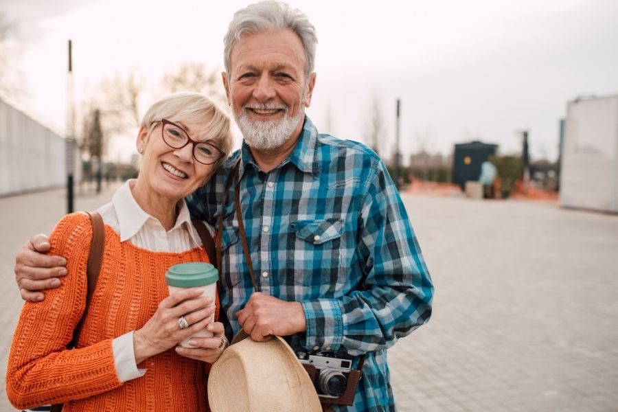 Older couple smiling and hugging facing camera