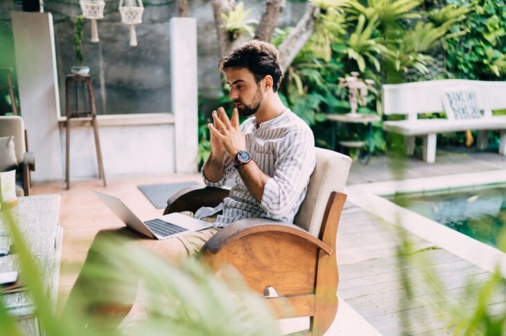 Serious financial-planning remote nomads with hands together working with laptop