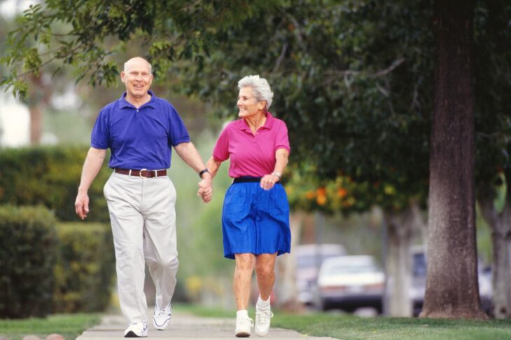 Senior couple walking side by side on sidewalk