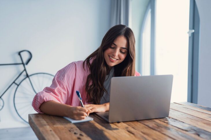 A housewife sits at a table using a personal organizer to create