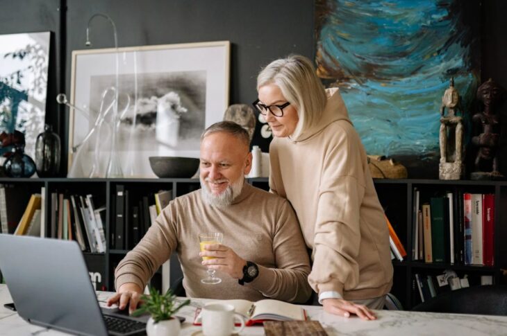 Couple in sweaters using a laptop together